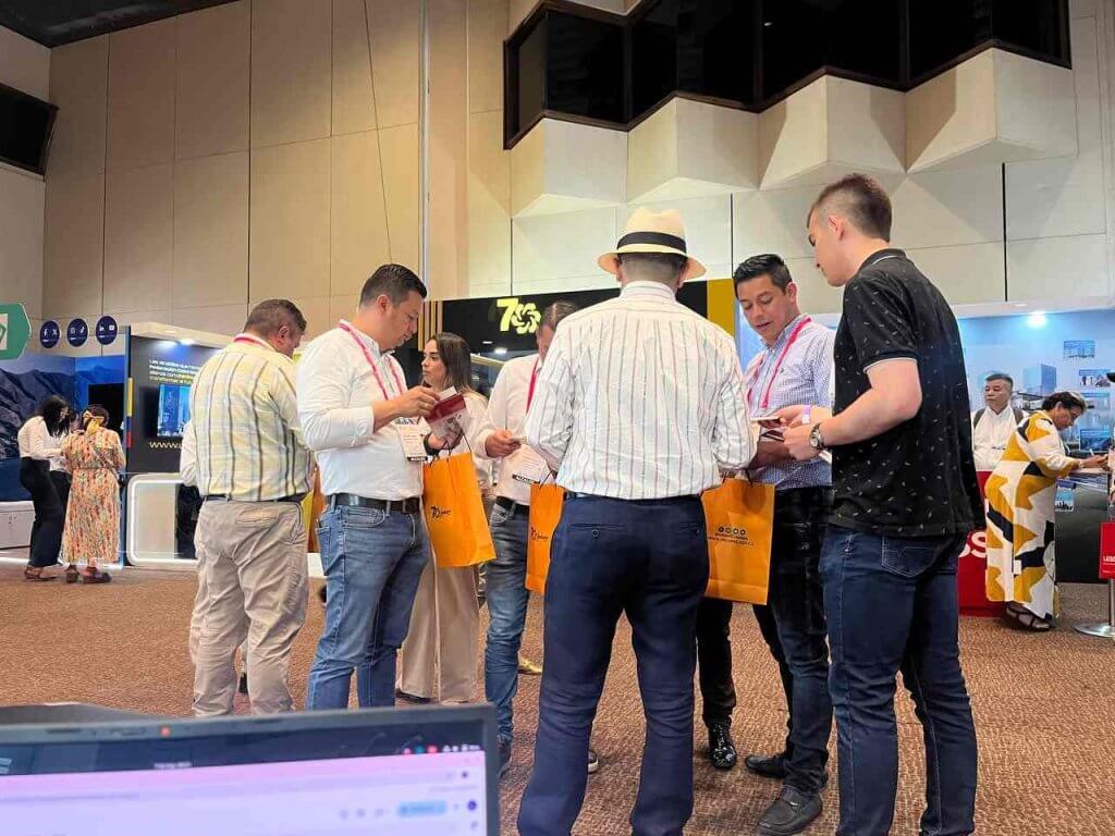 Equipo de trabajo hablando con alcaldes en el congreso nacional de municipios